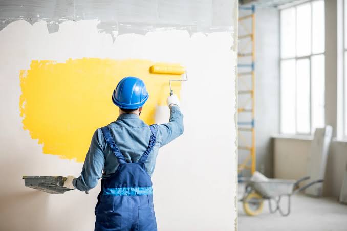 Painter brushing trim and doorframe during an interior repaint in Durango, Colorado